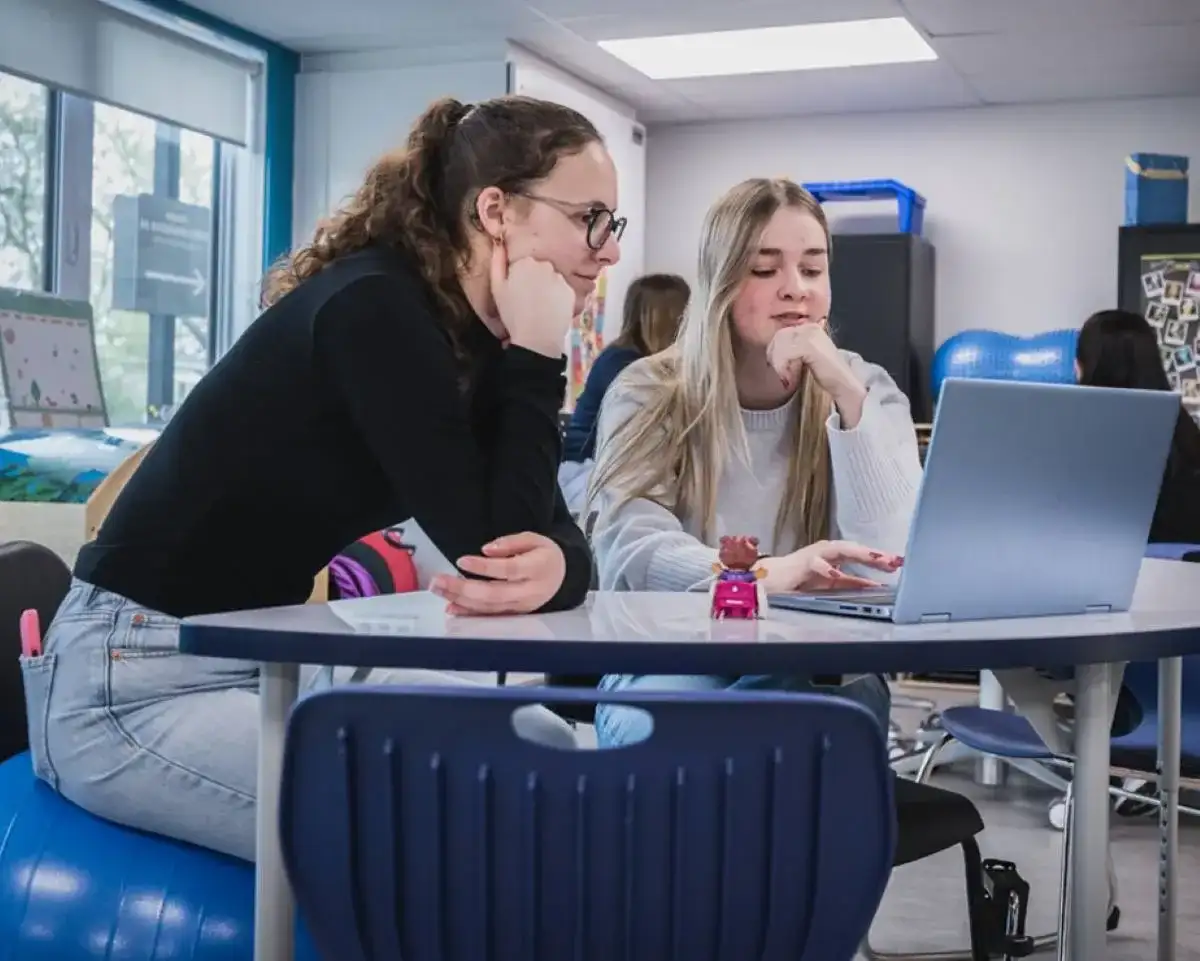 Deux étudiantes en discussion en face d'un ordinateur