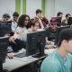 Personnes étudiantes en classe devant les ordinateurs