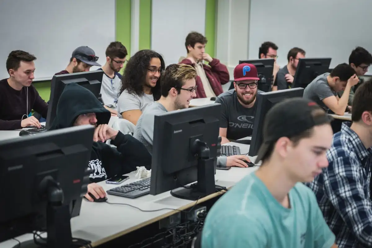 Personnes étudiantes en classe devant les ordinateurs