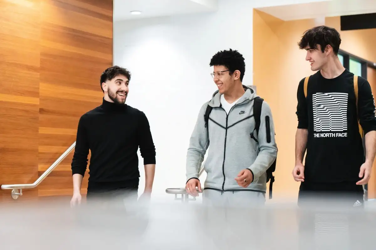 Personnes étudiantes qui discutent dans le corridor