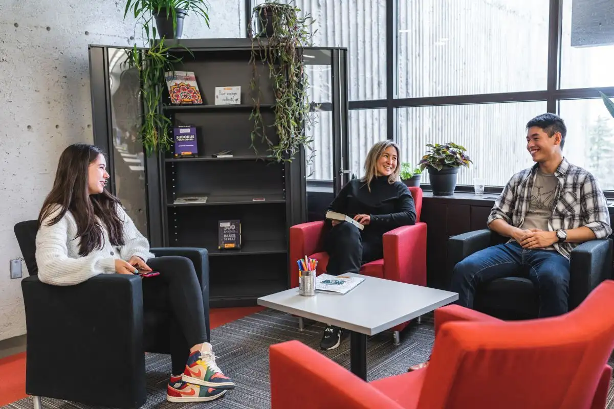 Personnes étudiantes assises qui discutent à la bibliothèque