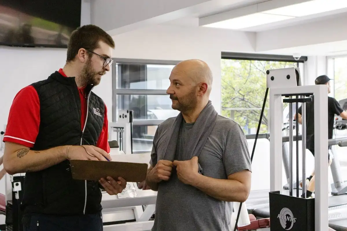 Un client se fait conseiller par un des kinésiologues du Centre sportif