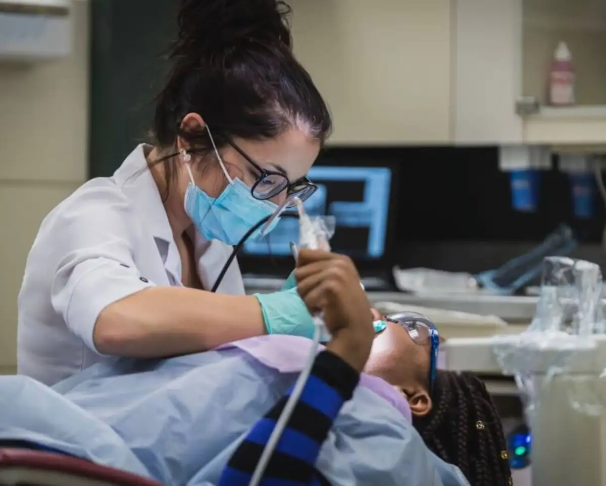 Personne qui regarde la bouche d'une patiente