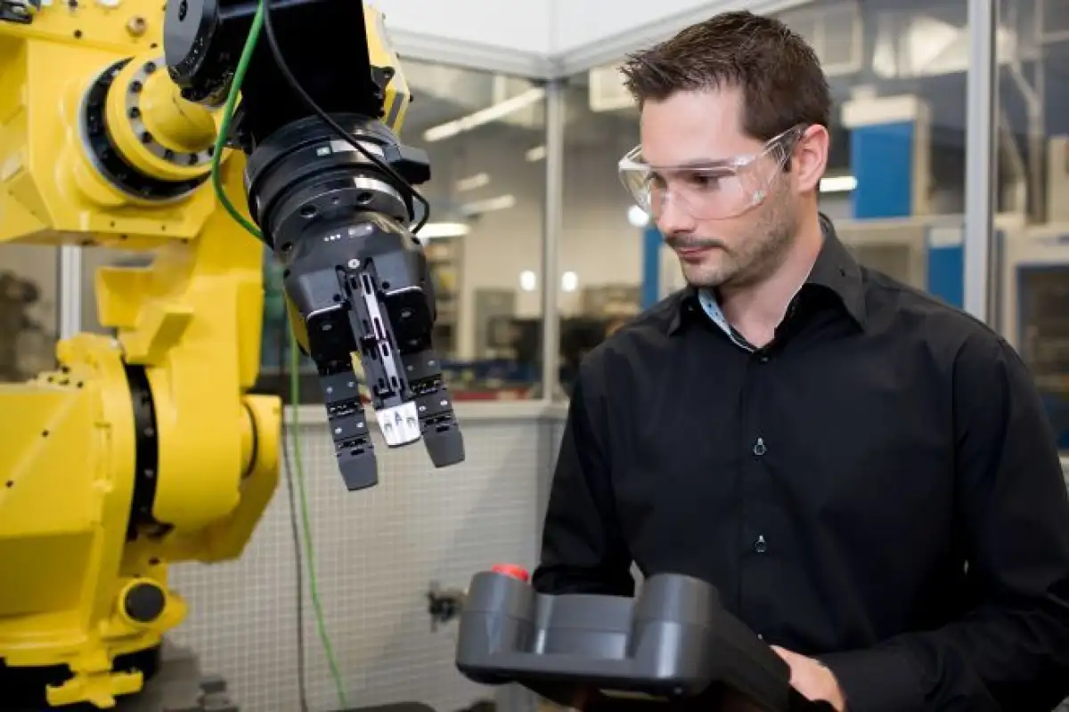 Un homme qui contrôle un bras robotique