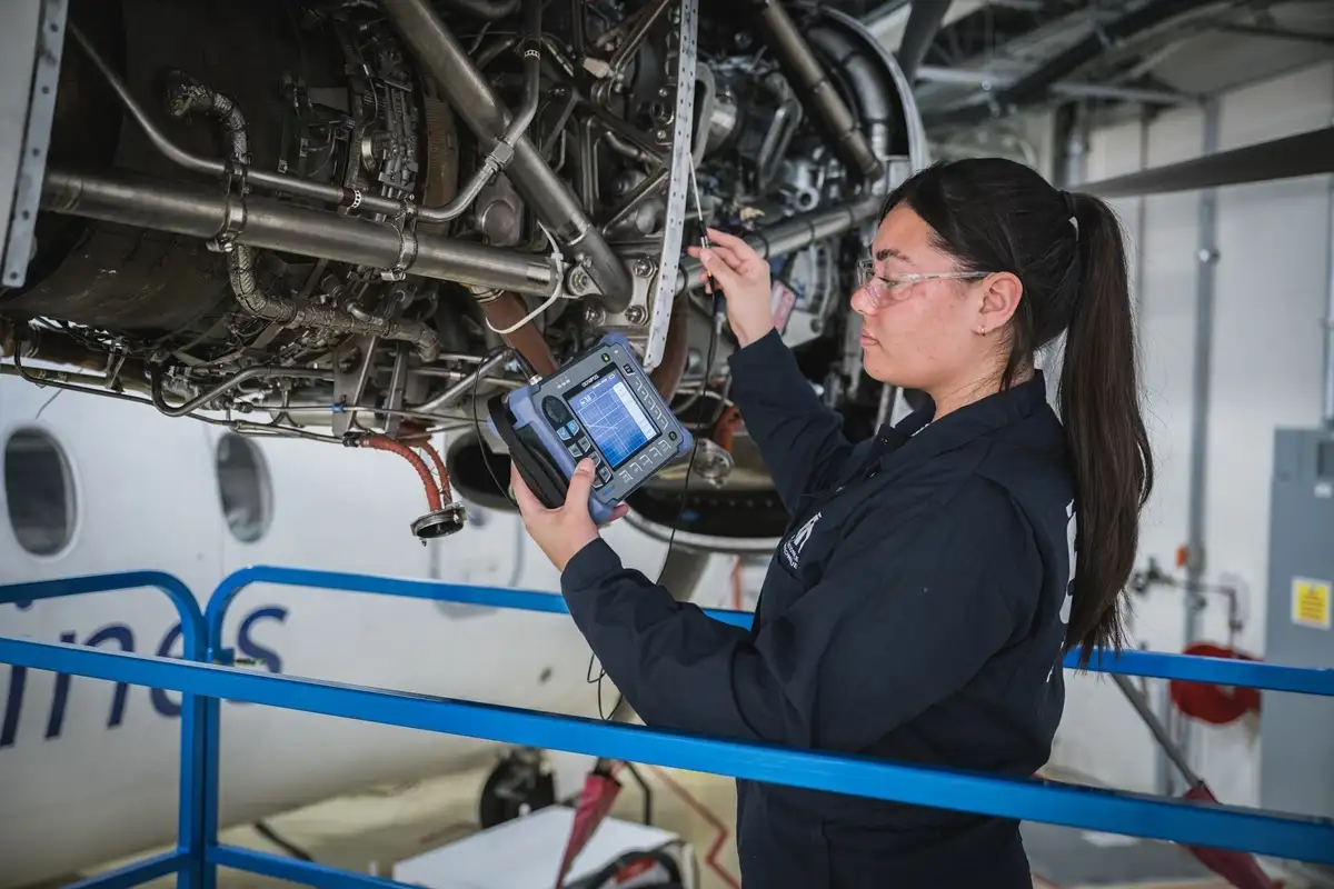 Etudiante inspectant un moteur d'avion